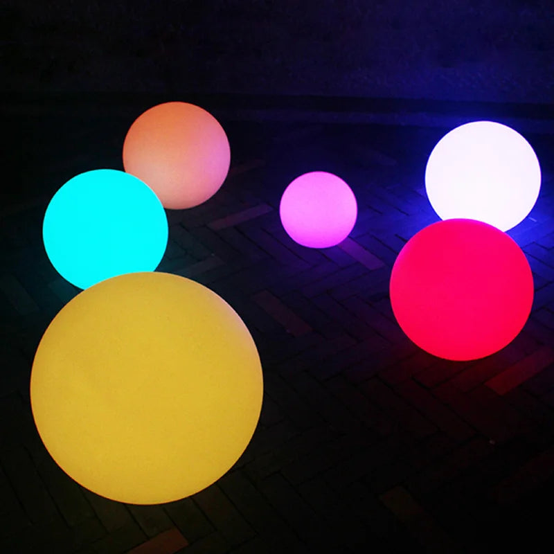 Waterproof RGB Color-Changing LED Ball Lights glowing in various colors on a dark surface, ideal for gardens, pools, and patios